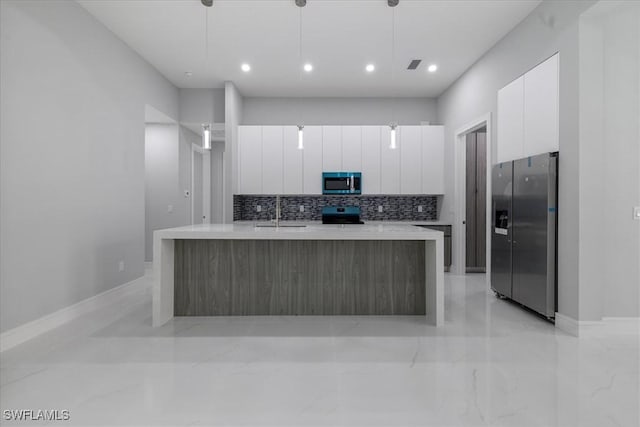 kitchen with pendant lighting, white cabinetry, stainless steel fridge with ice dispenser, range with electric stovetop, and a kitchen island with sink