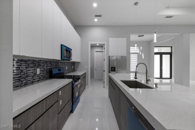 kitchen with stainless steel refrigerator with ice dispenser, electric stove, hanging light fixtures, white cabinets, and sink