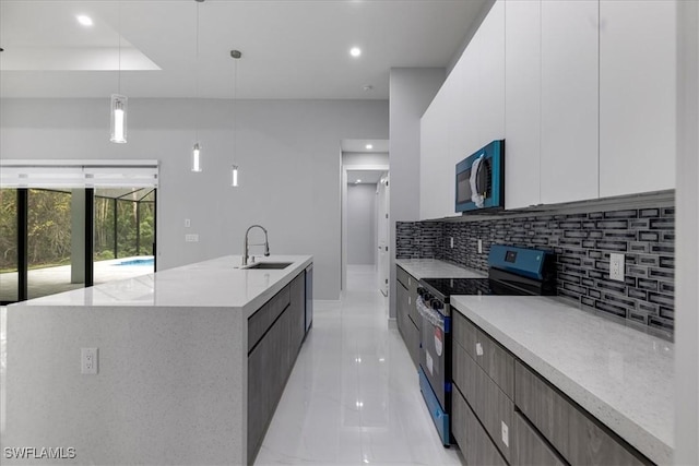 kitchen with a spacious island, stainless steel electric stove, pendant lighting, white cabinets, and sink