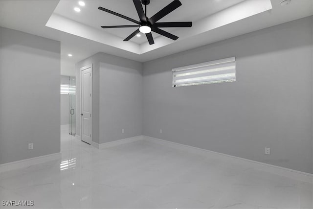 unfurnished room featuring ceiling fan and a tray ceiling