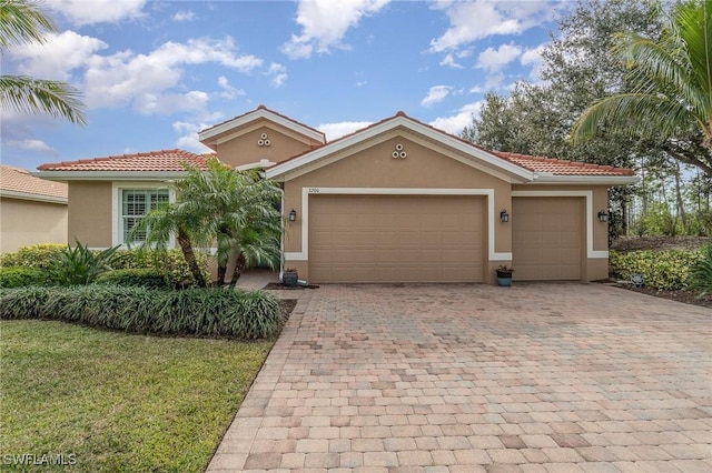 3200 Magnolia Landing Ln, North Fort Myers, FL 33917 - mediterranean / spanish-style home featuring stucco siding, decorative driveway, an attached garage, a tile roof, and a front lawn