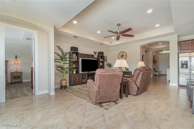 3200 Magnolia Landing Ln, North Fort Myers, FL 33917 - living room featuring a tray ceiling, recessed lighting, a ceiling fan, arched walkways, and light tile patterned floors
