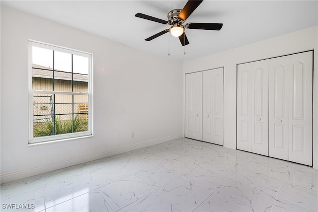 unfurnished bedroom featuring two closets and ceiling fan