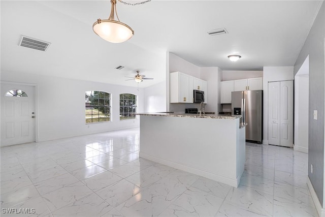 kitchen with white cabinetry, light stone counters, decorative light fixtures, ceiling fan, and stainless steel appliances