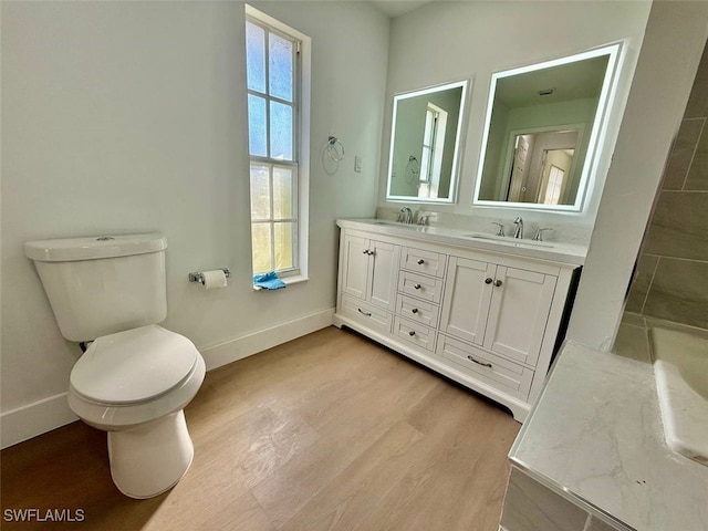 bathroom with wood-type flooring, toilet, and vanity