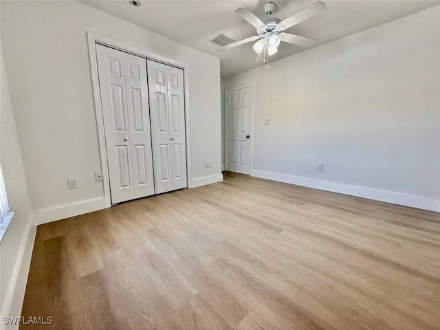 unfurnished bedroom with ceiling fan, light hardwood / wood-style flooring, and a closet