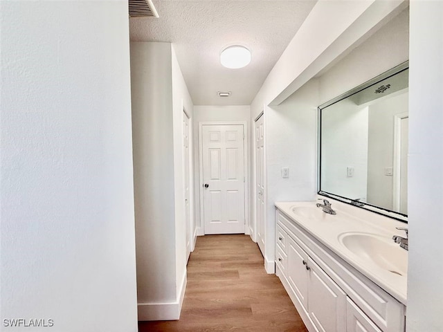 bathroom featuring hardwood / wood-style flooring, a textured ceiling, and vanity