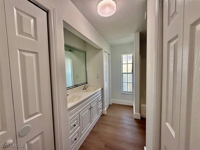 bathroom featuring hardwood / wood-style floors, vanity, and a textured ceiling