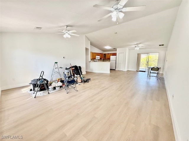 exercise area with light wood-type flooring and lofted ceiling