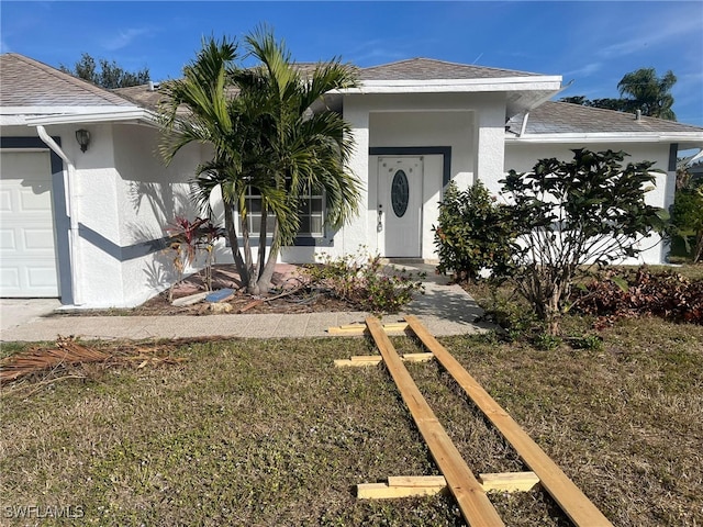 view of front of home with a garage and a front lawn