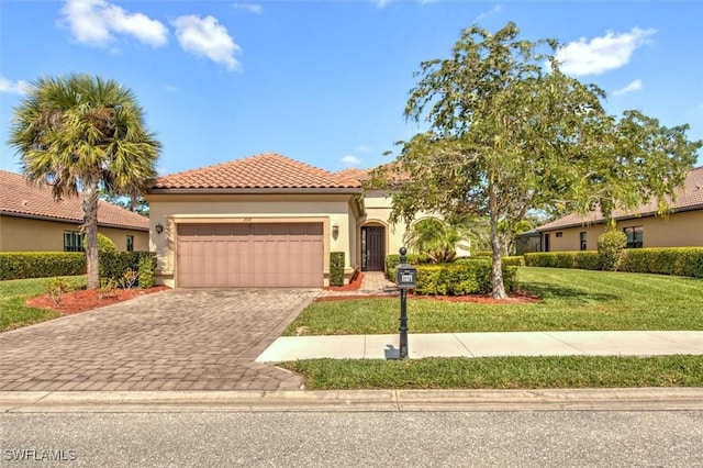 mediterranean / spanish-style home featuring a garage and a front yard