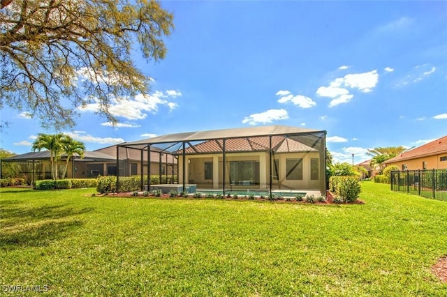 rear view of house featuring glass enclosure, a pool, and a yard