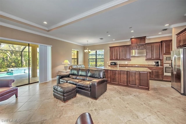 living room featuring sink, a notable chandelier, and ornamental molding