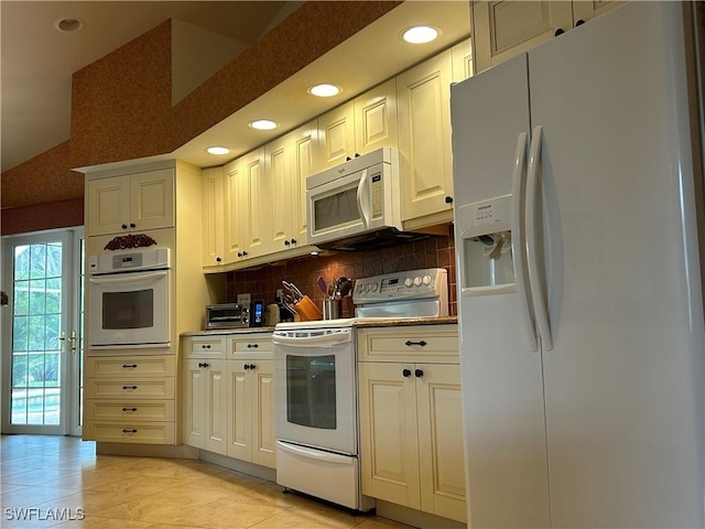 kitchen featuring vaulted ceiling, white appliances, decorative backsplash, and light tile patterned floors