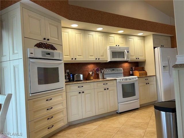 kitchen with light tile patterned flooring, white appliances, lofted ceiling, and tasteful backsplash