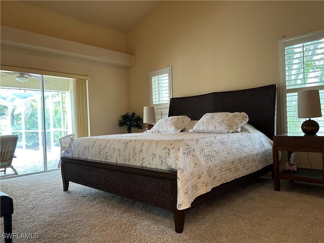 carpeted bedroom with high vaulted ceiling, multiple windows, and access to outside