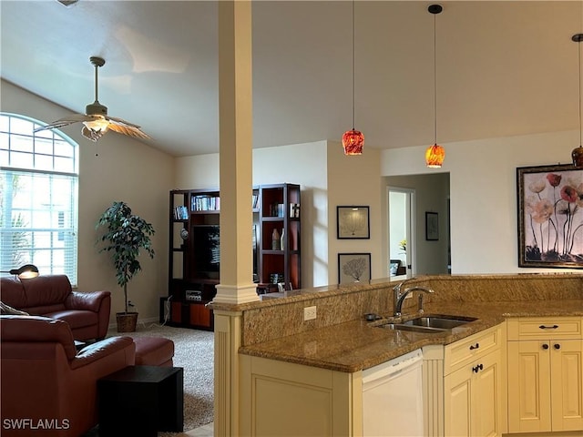 kitchen featuring light stone countertops, decorative light fixtures, sink, white dishwasher, and light colored carpet