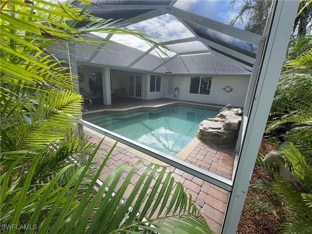 view of swimming pool with a patio and glass enclosure