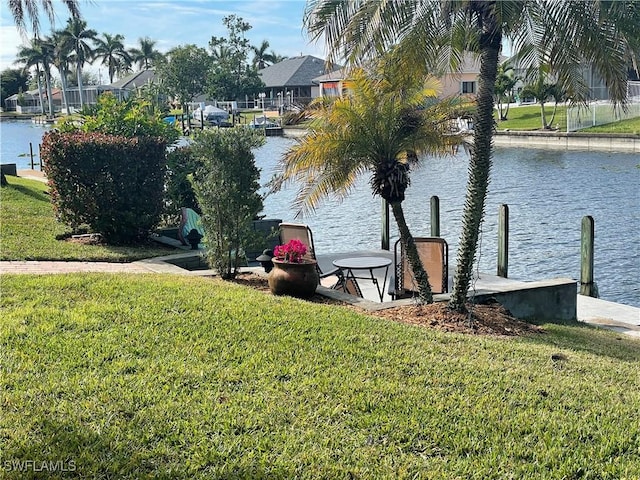 view of dock featuring a lawn and a water view