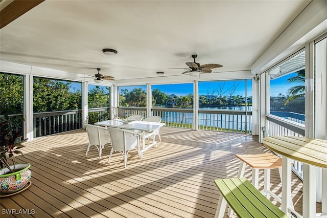 deck with a water view and ceiling fan