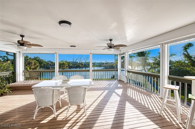 sunroom / solarium featuring a water view and ceiling fan