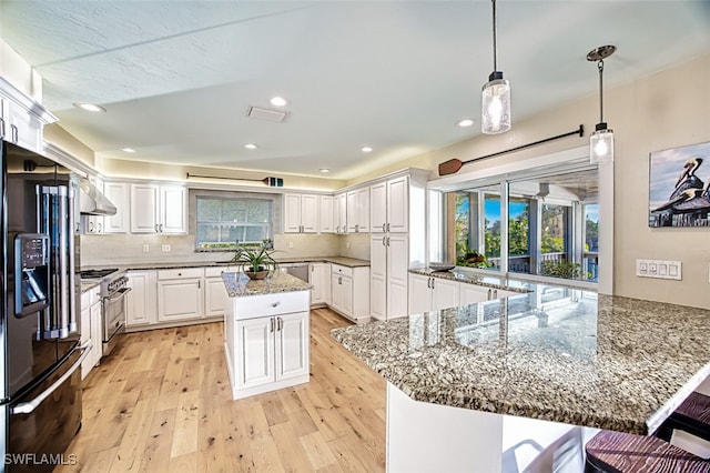 kitchen with white cabinetry, a large island, dark stone counters, stainless steel range, and black fridge with ice dispenser