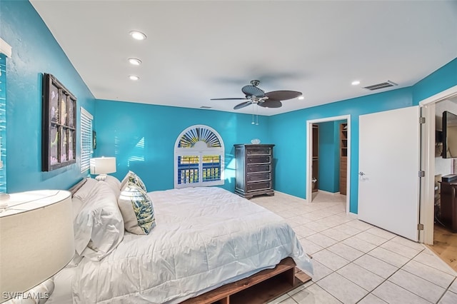 bedroom with light tile patterned flooring, a closet, ceiling fan, and a walk in closet