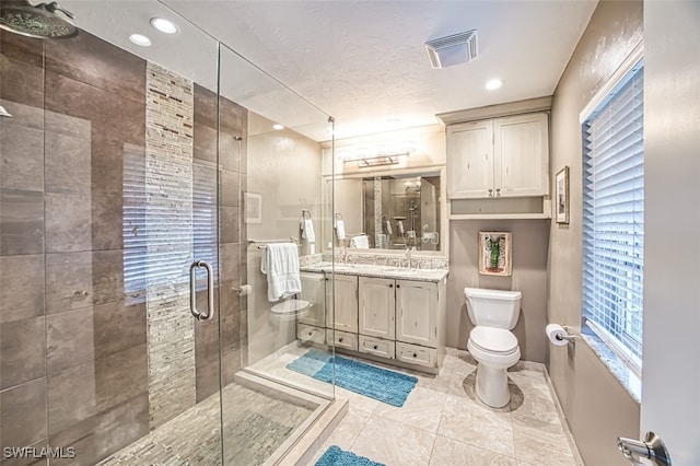 bathroom with toilet, walk in shower, and vanity