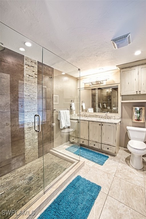 bathroom featuring vanity, toilet, and a shower with door