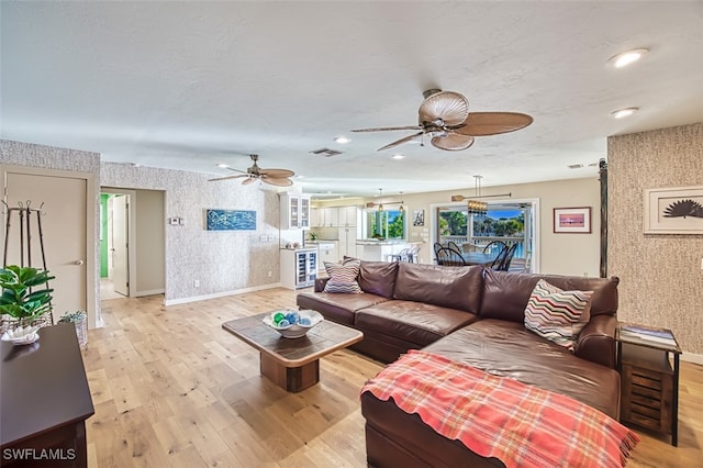 living room with ceiling fan and light hardwood / wood-style flooring