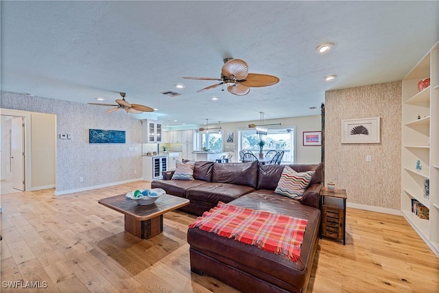 3131 Twin Lakes Ln, Sanibel, FL 33957 - living area with baseboards, light wood-type flooring, wallpapered walls, and a ceiling fan