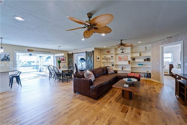 3131 Twin Lakes Ln, Sanibel, FL 33957 - living area featuring light wood-style flooring, ceiling fan, a barn door, and baseboards
