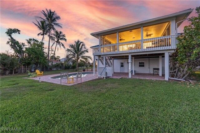 3131 Twin Lakes Ln, Sanibel, FL 33957 - back of property at dusk with ceiling fan, a yard, a patio, fence, and stairs