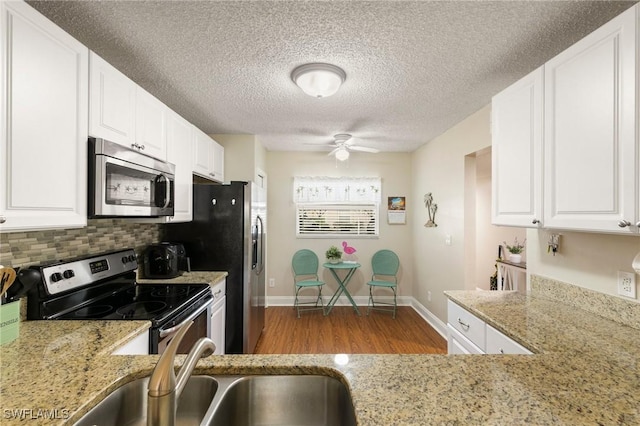 kitchen with white cabinetry, sink, backsplash, and appliances with stainless steel finishes