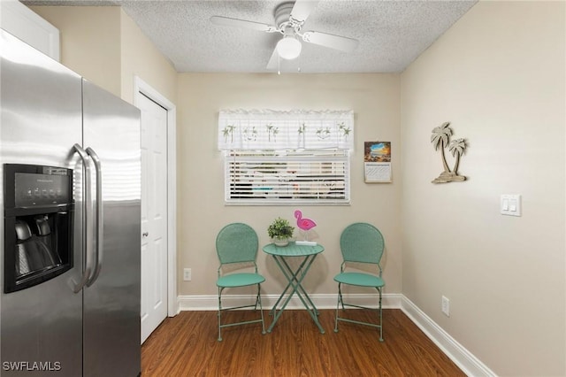 sitting room with ceiling fan, dark wood-type flooring, a wealth of natural light, and a textured ceiling