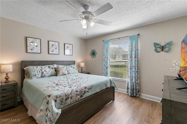 bedroom with ceiling fan, a textured ceiling, and light wood-type flooring