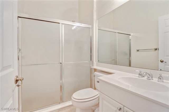 bathroom with vanity, toilet, and an enclosed shower