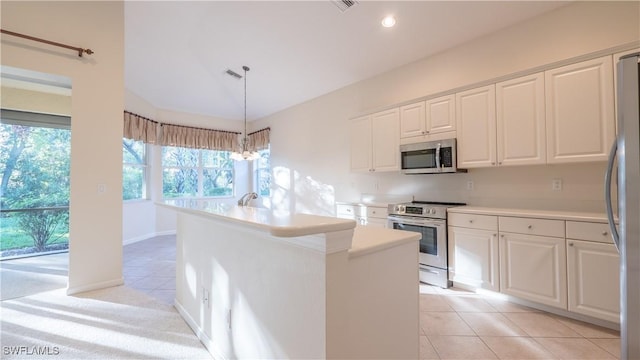 kitchen with appliances with stainless steel finishes, white cabinetry, hanging light fixtures, a kitchen island with sink, and light tile patterned floors