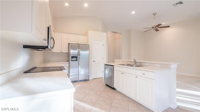 kitchen featuring vaulted ceiling, appliances with stainless steel finishes, sink, white cabinets, and an island with sink