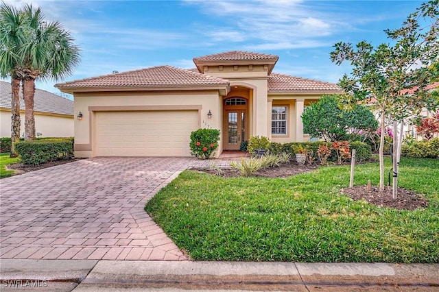 mediterranean / spanish-style house featuring a garage and a front yard