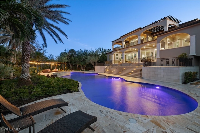 pool at dusk with a patio area