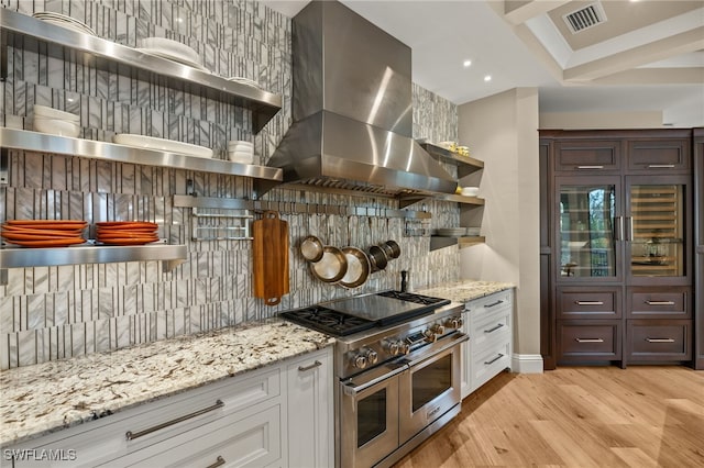 kitchen with light hardwood / wood-style flooring, backsplash, double oven range, island exhaust hood, and white cabinets