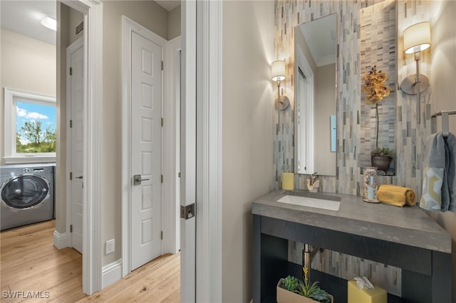 330 Cowry Ct, Sanibel, FL 33957 - bathroom featuring crown molding, vanity, wood finished floors, washer / clothes dryer, and baseboards