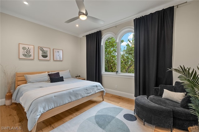 bedroom with crown molding, ceiling fan, and light hardwood / wood-style flooring