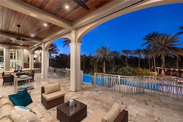 patio terrace at dusk featuring outdoor lounge area and ceiling fan