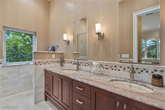 bathroom featuring walk in shower, vanity, tile patterned flooring, and tile walls