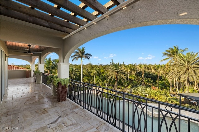 balcony featuring ceiling fan and a pergola