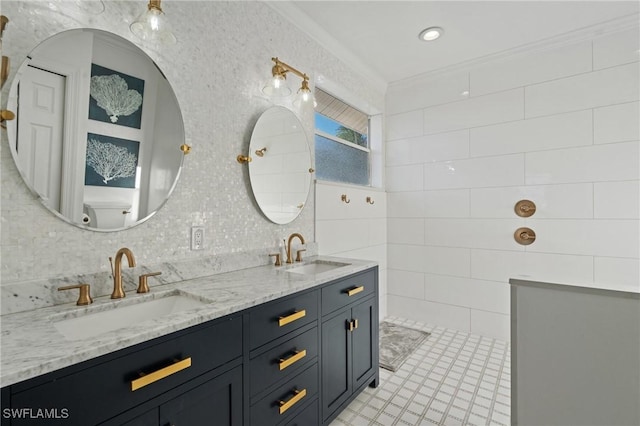 full bath featuring double vanity, a sink, tile walls, and crown molding