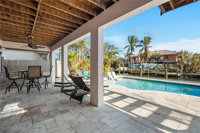 view of pool with ceiling fan, fence, and a patio