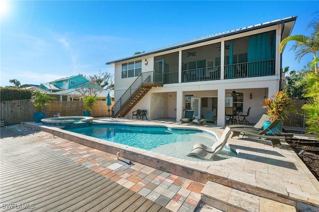 back of house with a patio, a fenced backyard, a pool with connected hot tub, a ceiling fan, and stairway